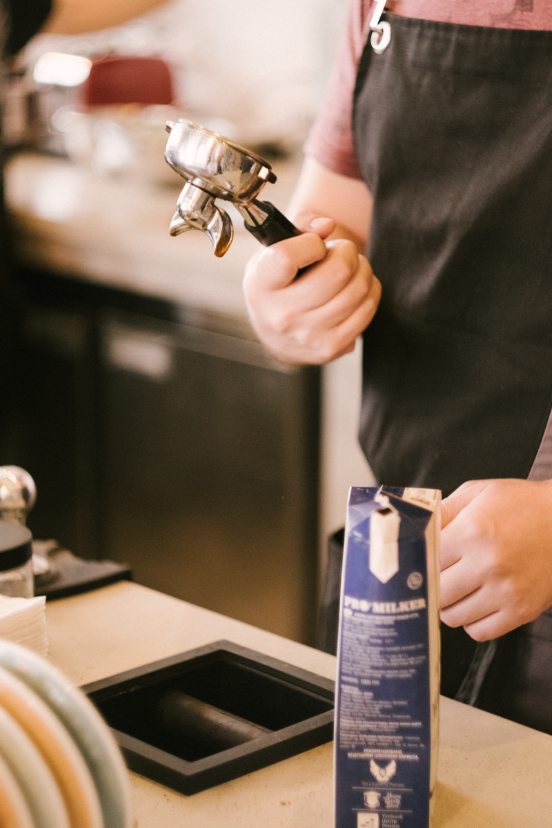 Barista pripravlja espresso pri točilnem pultu v kavarni Dobro Jutro Kava